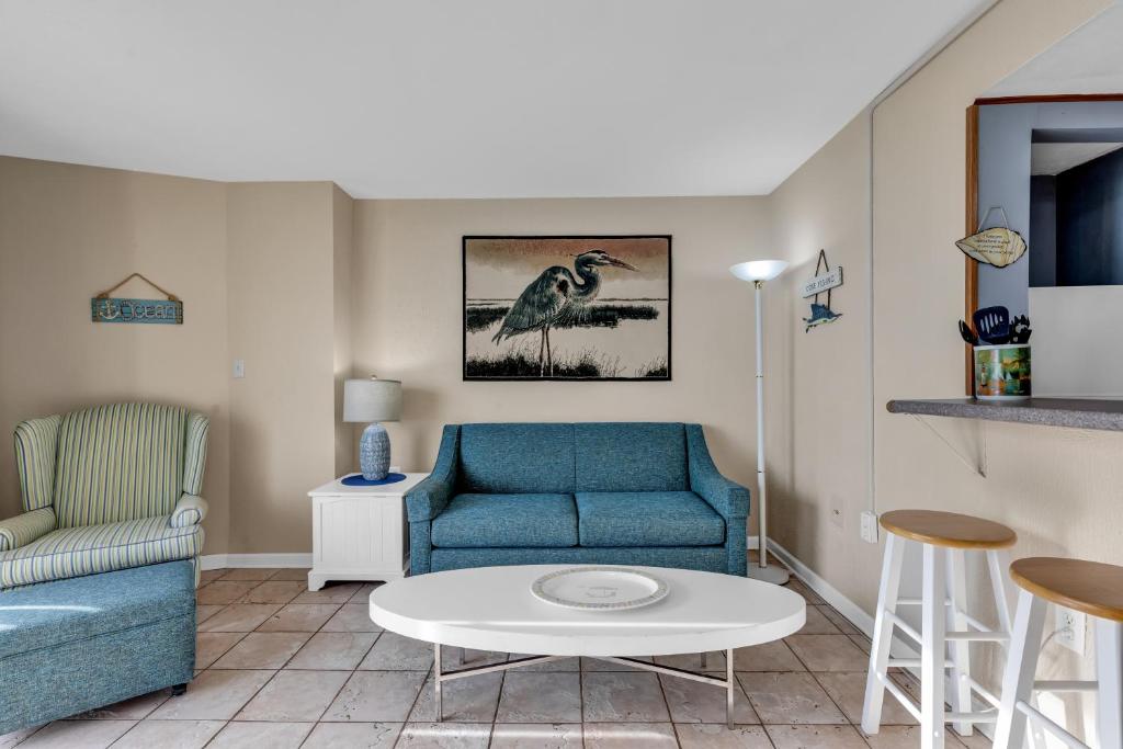 ein Wohnzimmer mit einem blauen Sofa und einem Tisch in der Unterkunft Hosteeva Oceanview Meridian Plaza Condo in Myrtle Beach