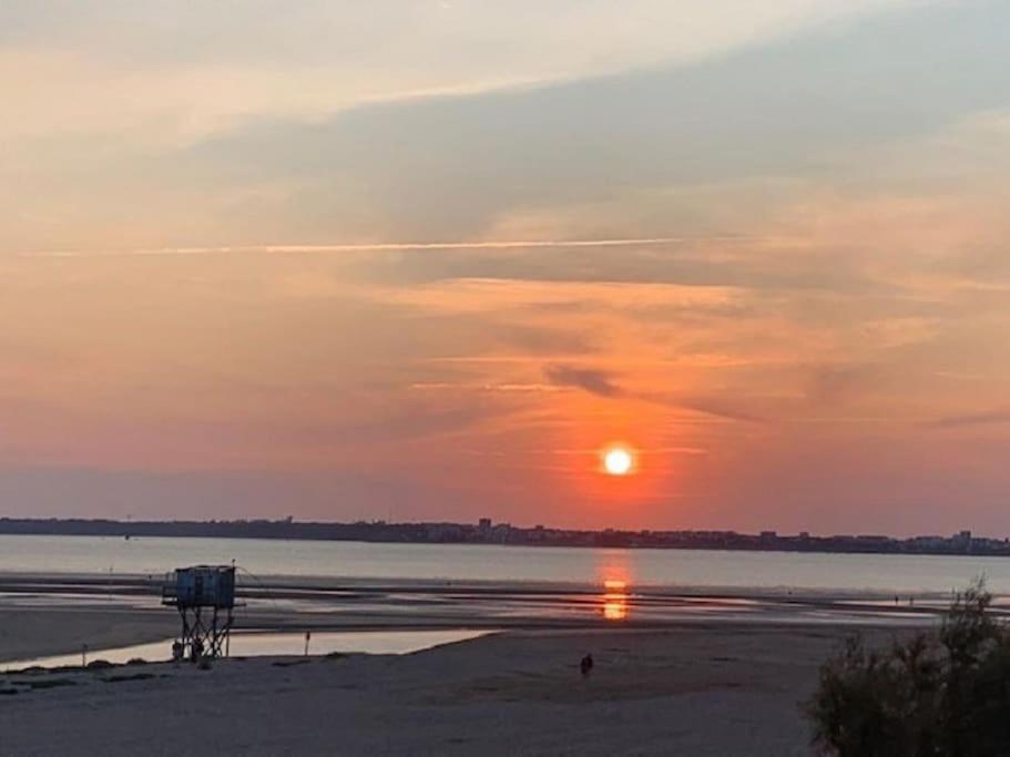zachód słońca na plaży z zachodem słońca w obiekcie Bel Appartement vue mer SAINT BREVIN LES PINS w mieście Saint-Brévin-les-Pins