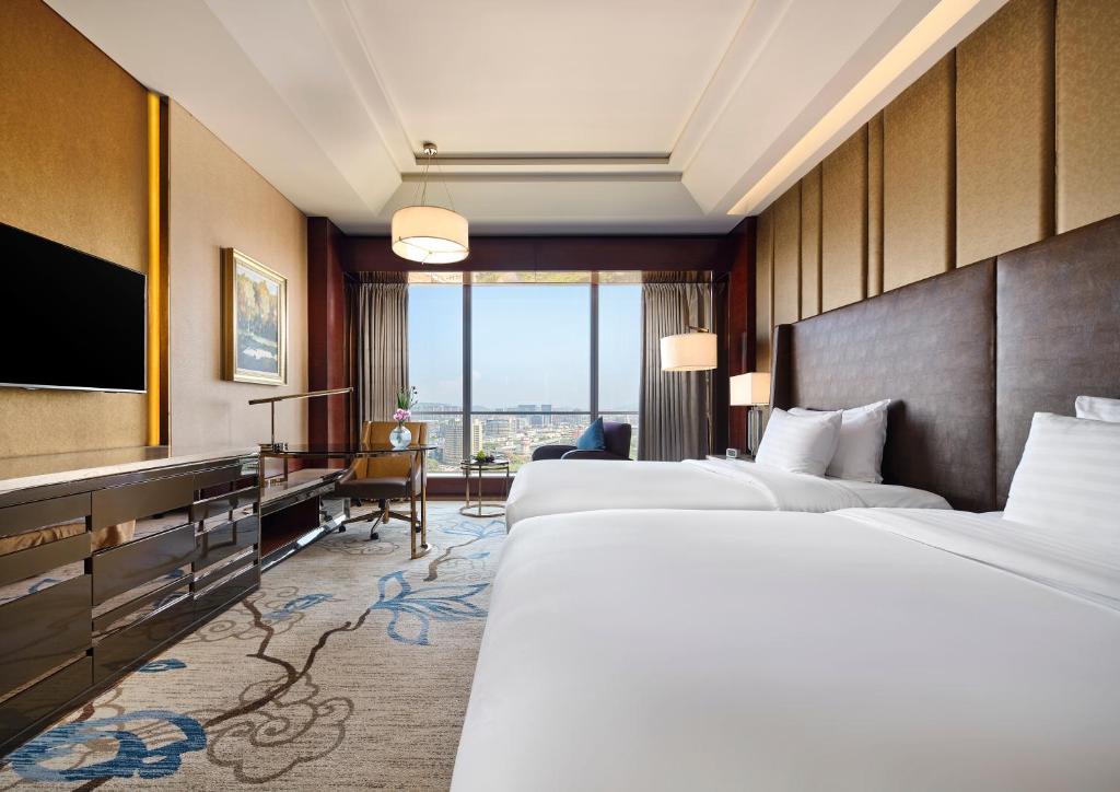 Postel nebo postele na pokoji v ubytování Sanding New Century Grand Hotel Yiwu