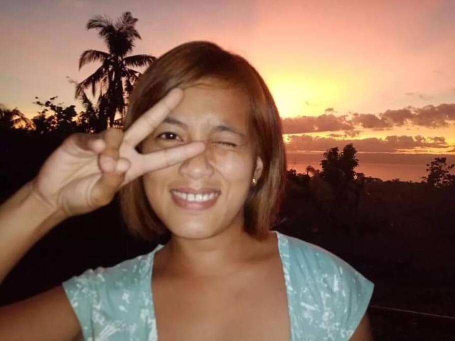 Uma mulher a fazer o sinal da paz com os dedos. em Vida Kristele Bohol em Loon