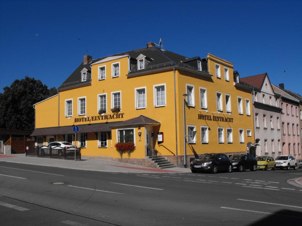 un edificio amarillo al lado de una calle en Hotel Eintracht, en Mittweida