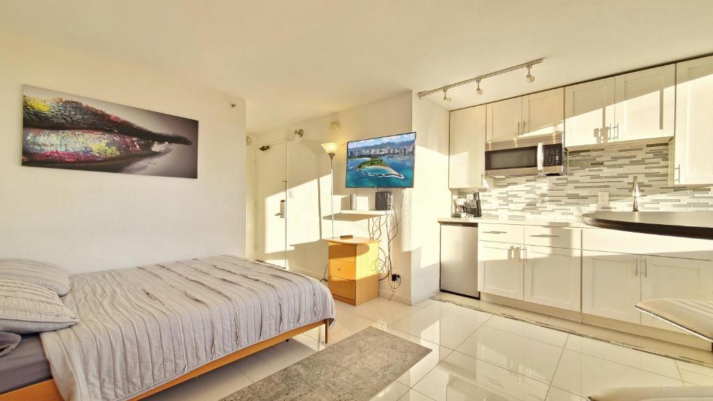 eine weiße Küche mit einem Bett und einem Waschbecken in der Unterkunft Waikiki beach cozy studio no resort fee in Honolulu