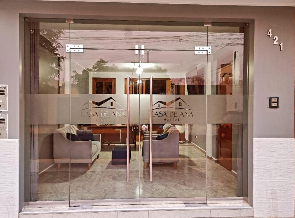 a glass wall in a living room with two couches at Hostal Casa de Ana in Nazca