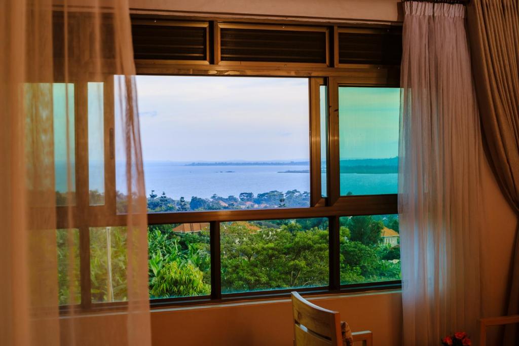 a window with a view of the ocean at Victoria View Boutique Hotels Kigo in Entebbe