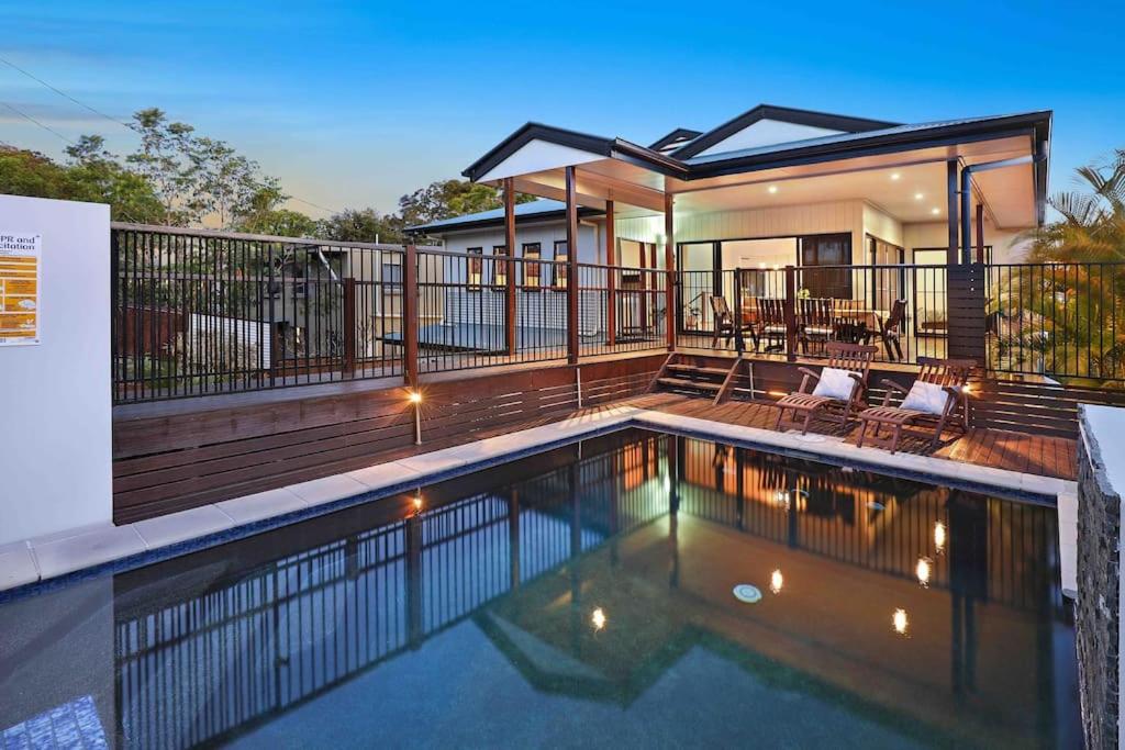 a house with a swimming pool on a deck at Luxury Holiday Home in Alex - Heated Pool - Pets Allowed in Alexandra Headland