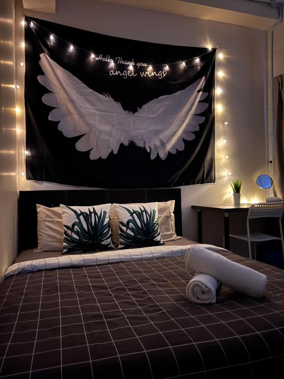 a bedroom with a large bed with an angel wings banner at Room3A#IG theme Bargainous#Shared Bathroom#3pax#2min Kek Lok Si in Ayer Itam