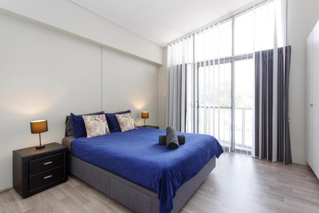 1 dormitorio con cama y ventana grande en Waverley apartment F-two bedrooms wifi available, en Perth