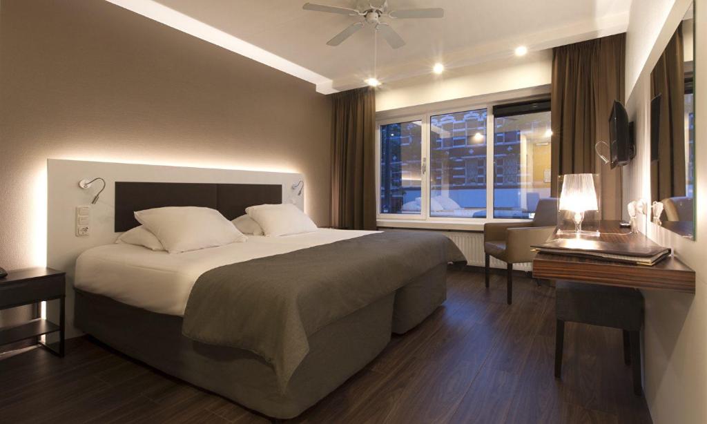 een slaapkamer met een groot bed en een raam bij Hotel Emma in Rotterdam