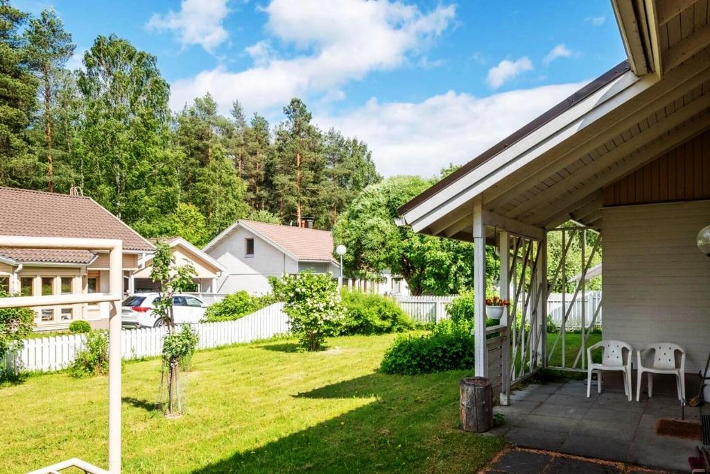ein Haus mit einem Garten mit Stühlen und einem Zaun in der Unterkunft Holiday Home - Detached house 108m2, 3 rooms, 1 living room, Sauna in Joensuu