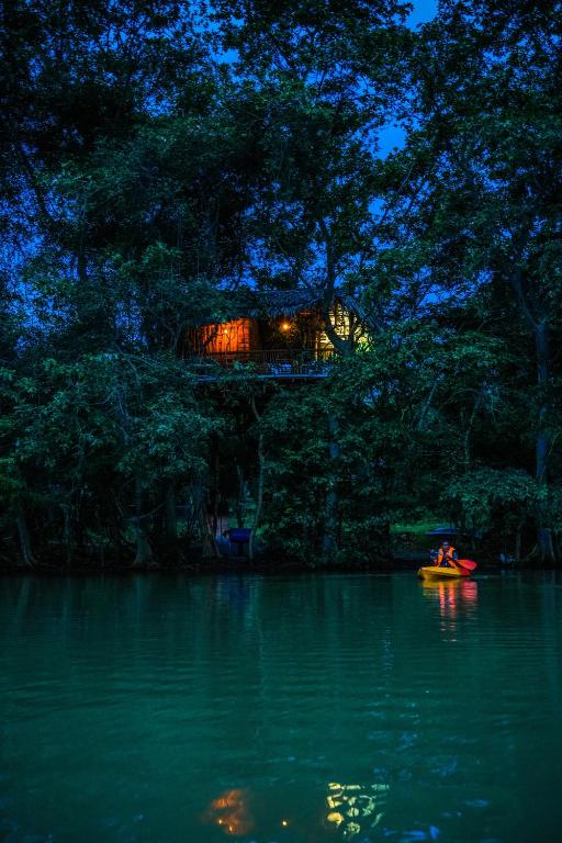 a person in a kayak on a river at night at Eco Bliss Cottages - Thanamalwila in Nikawewa