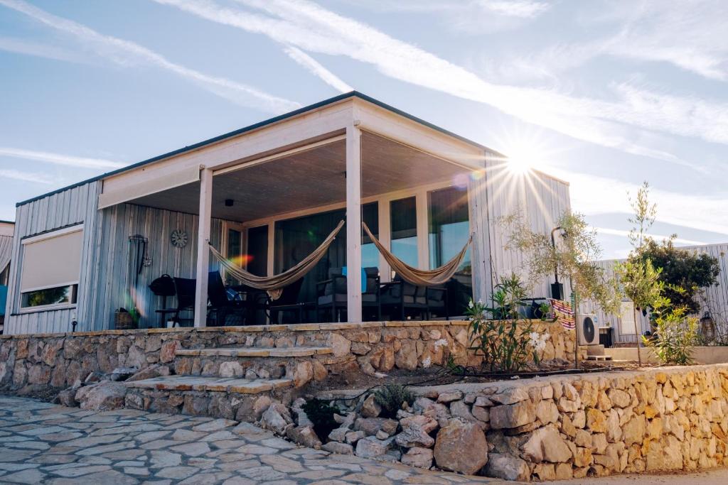 Buqez resort Drage, villa Vita 50 في باكوشتاني: منزل بحائط حجري والشمس ساطعة عليه