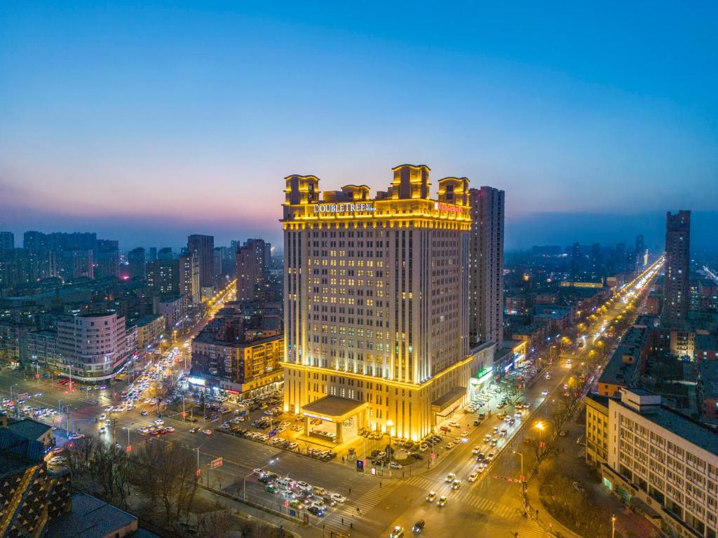 a lit up building in a city at night at Doubletree By Hilton Anshan in Anshan