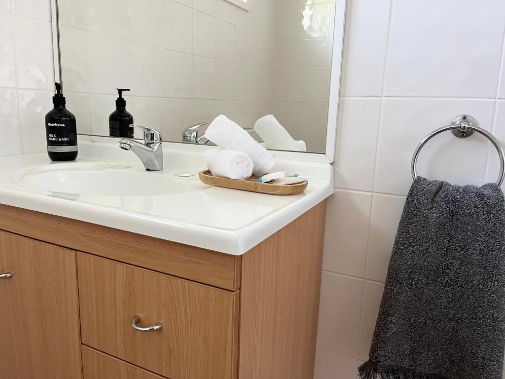 a bathroom with a sink and a mirror at Som House 1 in Shoal Bay