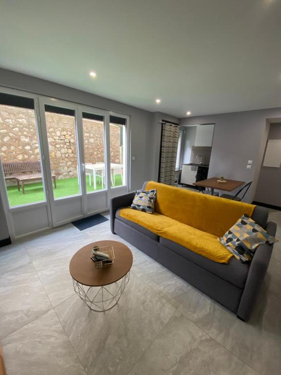 un salon avec un canapé jaune et une table dans l'établissement Studio standing bord de mer, à Mandelieu-la-Napoule