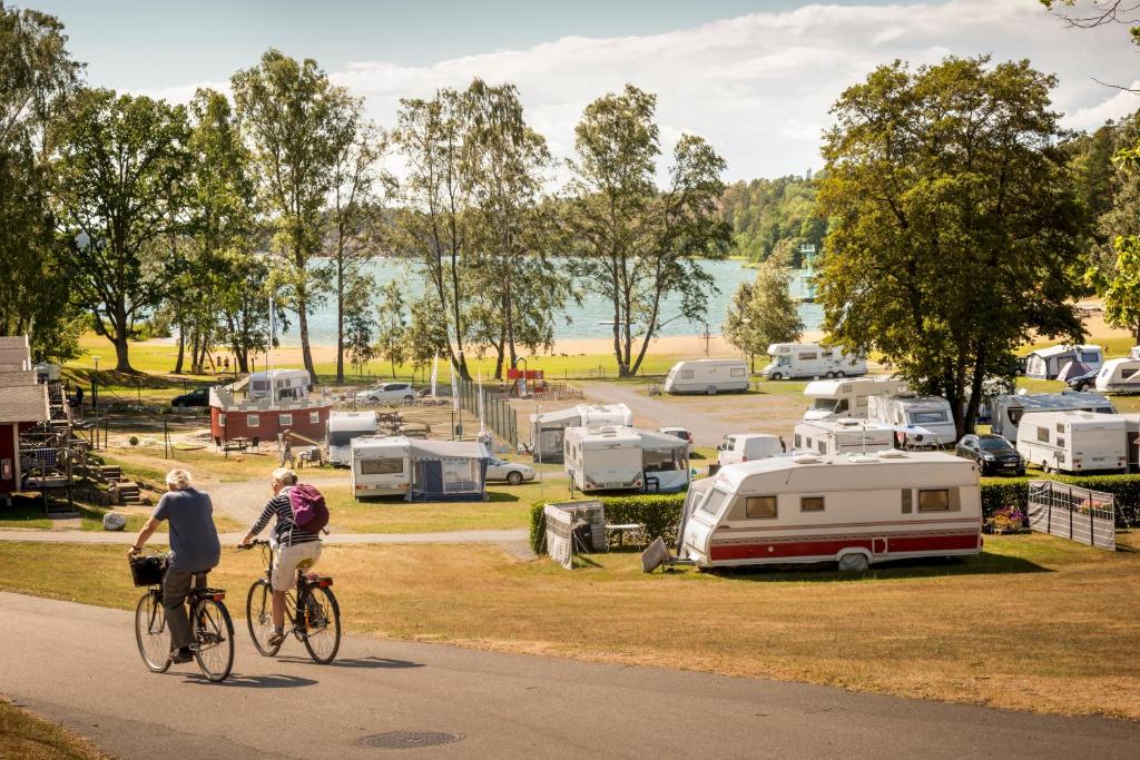 two people riding bikes down a road near a campgrounds at First Camp Nickstabadet-Nynäshamn in Nynäshamn