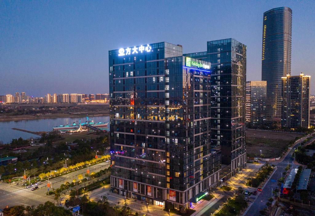 南昌市にあるHoliday Inn Express Nanchang Riverside, an IHG Hotelの夜の高層ビル