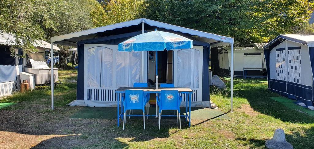 伊塞奧的住宿－Camping Pilzone，蓝色帐篷,配有两把椅子和一把伞