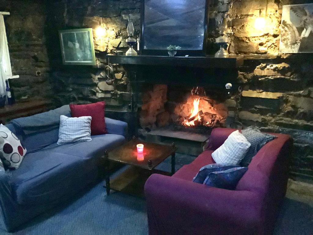 a living room with two couches and a fireplace at Rustic miners cabin in Faraday
