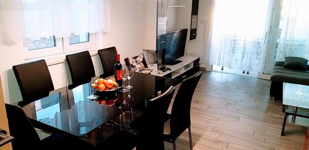 salon ze stołem, krzesłami i telewizorem w obiekcie Ferienappartment Mary w mieście Skunca