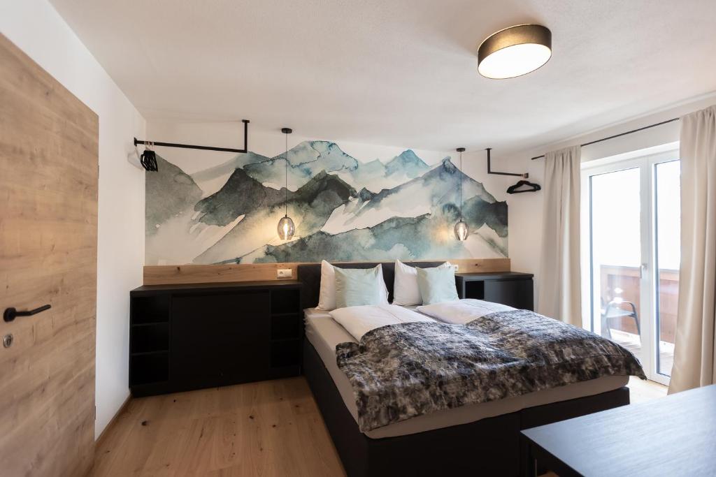 ein Schlafzimmer mit einem Bett und einem Wandgemälde in der Unterkunft Landhaus Riepler in Wagrain