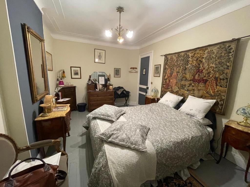 - une chambre avec un lit et une tapisserie sur le mur dans l'établissement Villa des Chats, à Calais