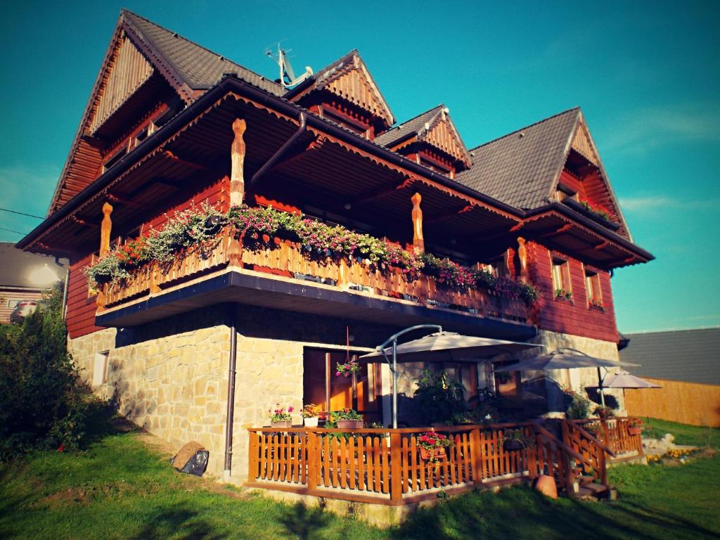 ein Haus mit einem Balkon mit Blumen darauf in der Unterkunft Pension Adamjak in Ždiar