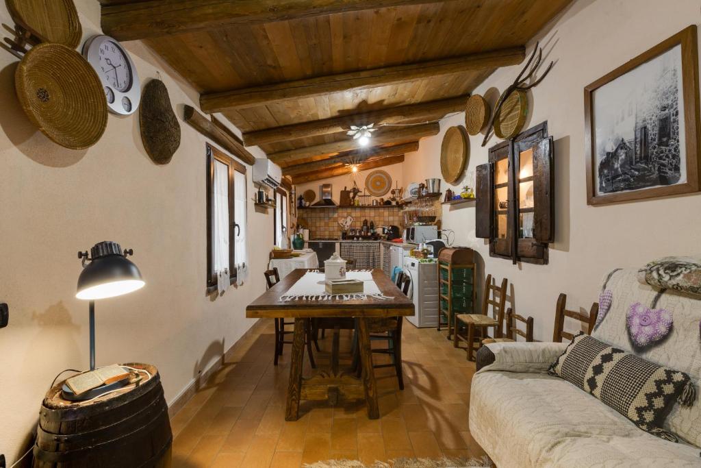 a kitchen and living room with a table and a couch at Antica dimora in Paulilatino