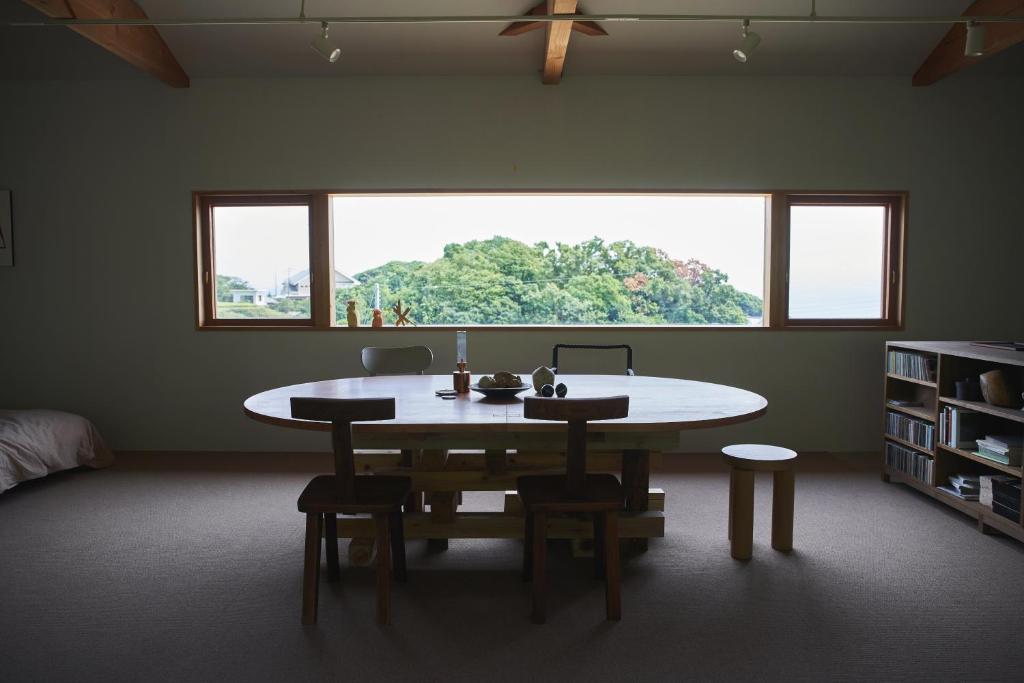 um quarto com uma mesa e cadeiras e uma janela em WORM em Awaji