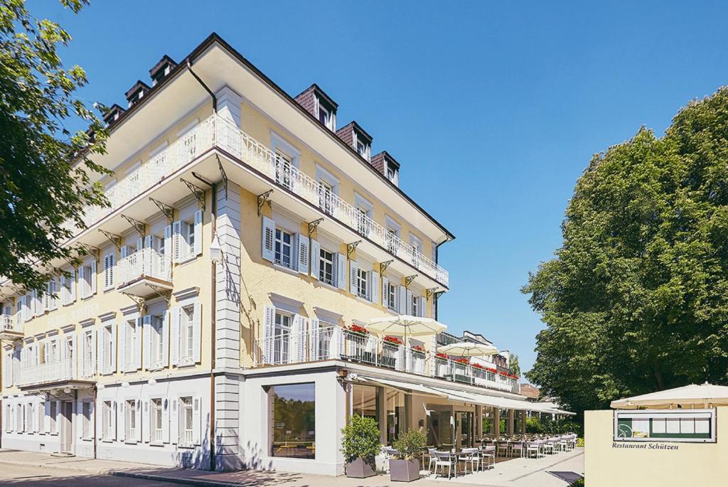 Un grand bâtiment blanc avec balcon se trouve dans une rue. dans l'établissement Hotel Schützen Rheinfelden, à Rheinfelden