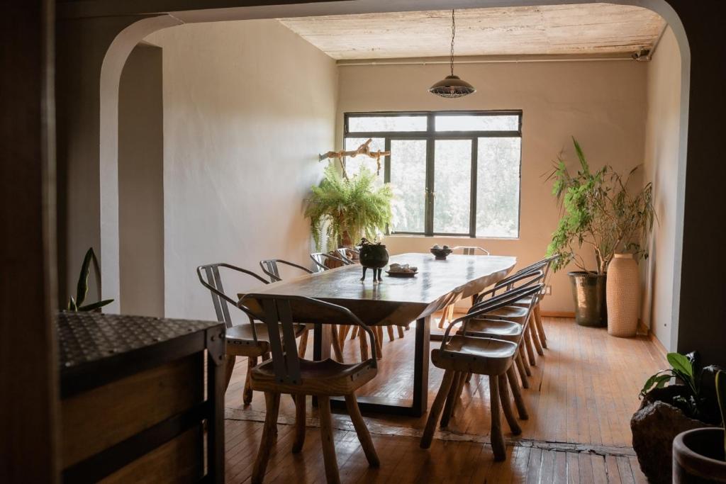 a dining room with a wooden table and chairs at Casa Lomah Hotel in Mexico City