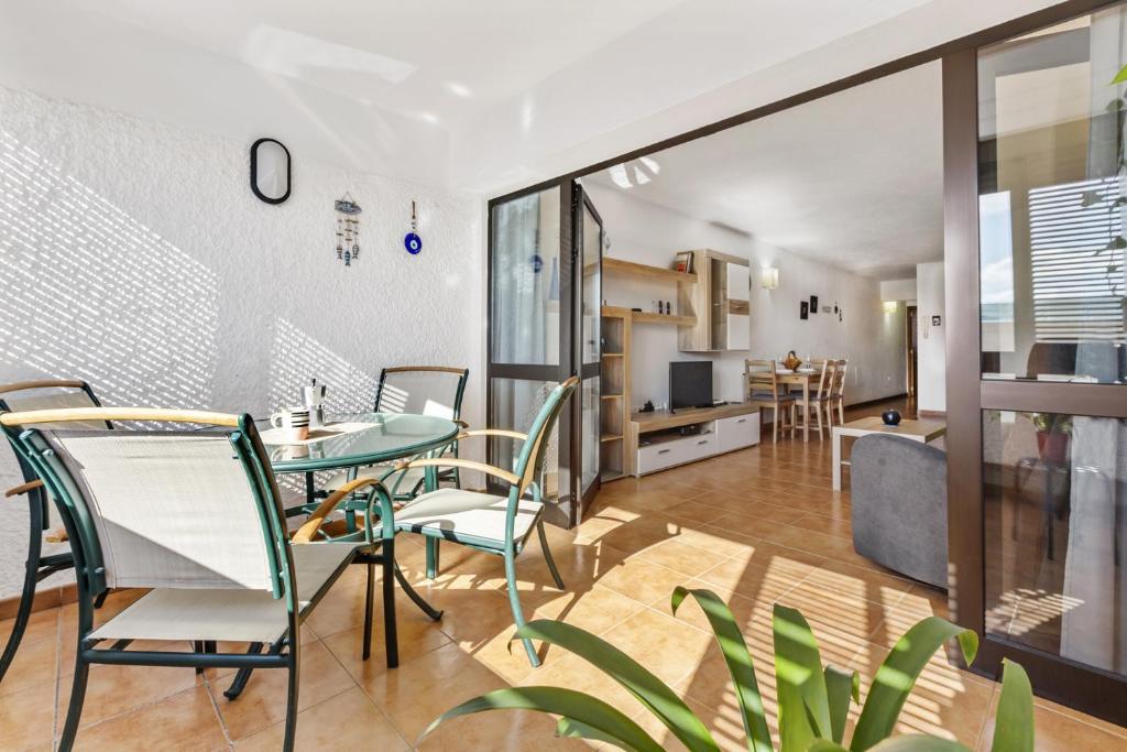 Una cocina y una sala de estar con mesa y sillas. en Apartamento Playa del Reducto, en Arrecife