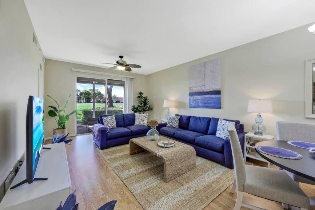 sala de estar con sofá azul y mesa en Beautiful 2 bedroom condo w/ Golf Membership Included en Naples