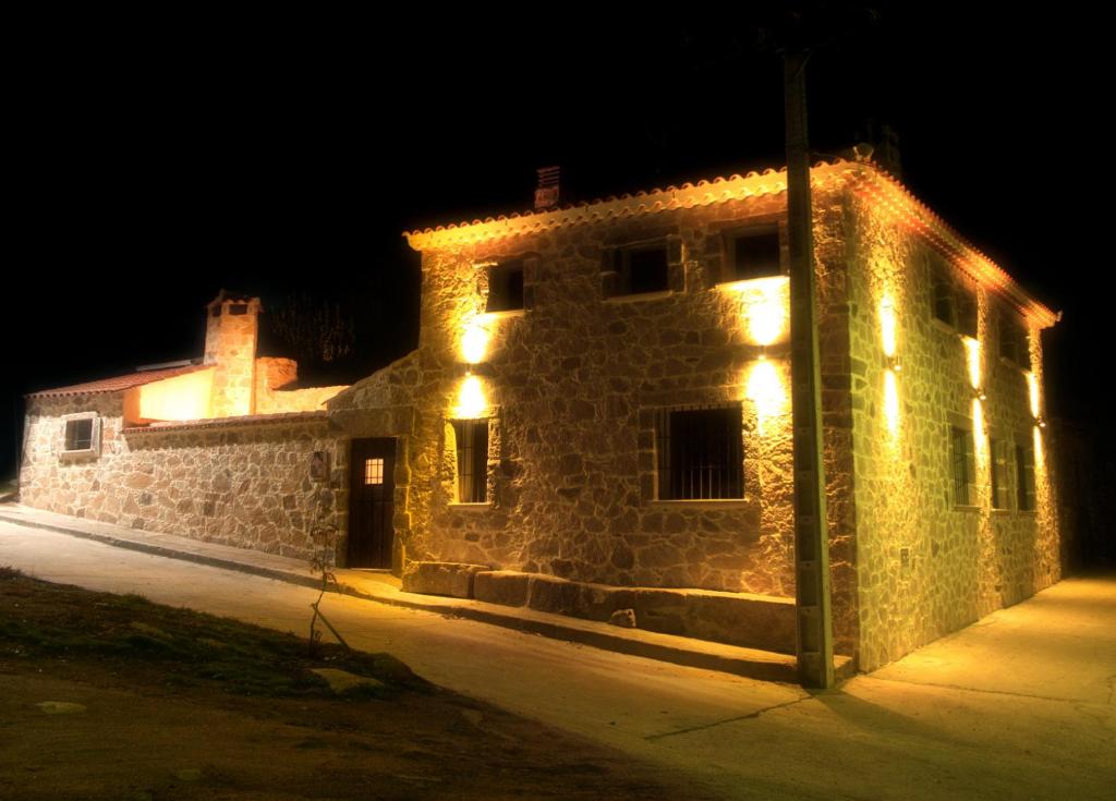 un edificio de piedra con luces encendidas por la noche en Casa Rural El Gorgocil en Puente del Congosto