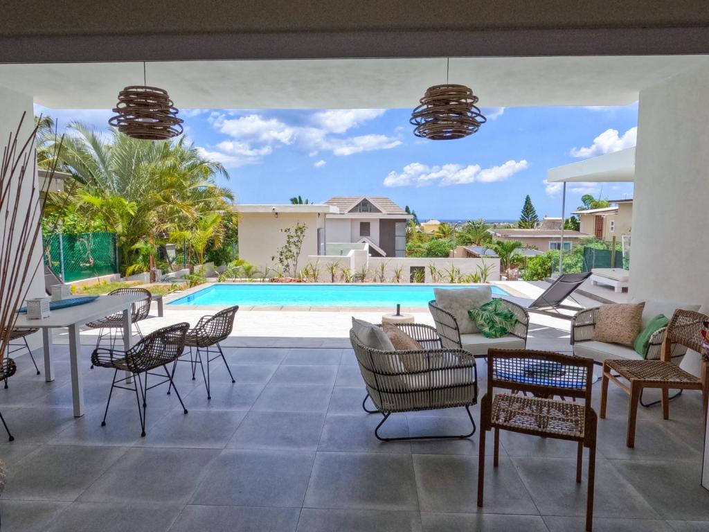 a patio with a table and chairs and a pool at ELOMY VILLA in Albion
