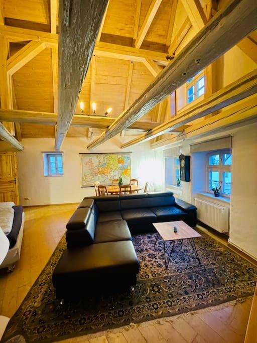 ein großes Wohnzimmer mit einem Sofa und einem Tisch in der Unterkunft Eine Etage im historischen Gästehaus bei Magdeburg in Barleben