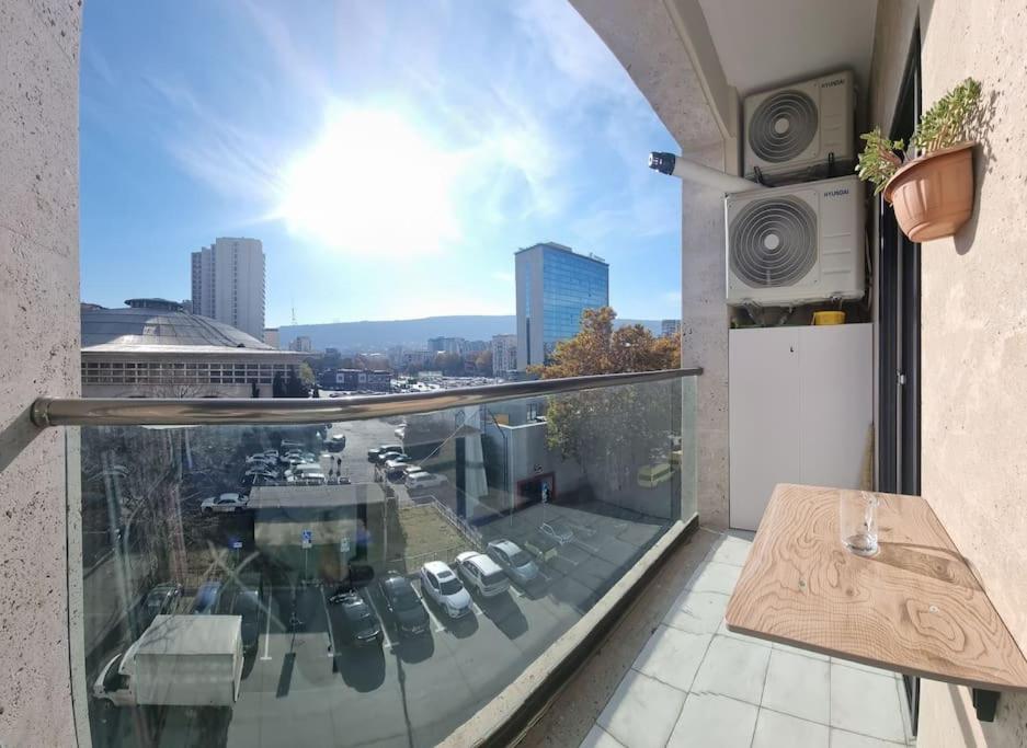 uma varanda com uma mesa e vista para a cidade em Morkinali Apartment em Tbilisi