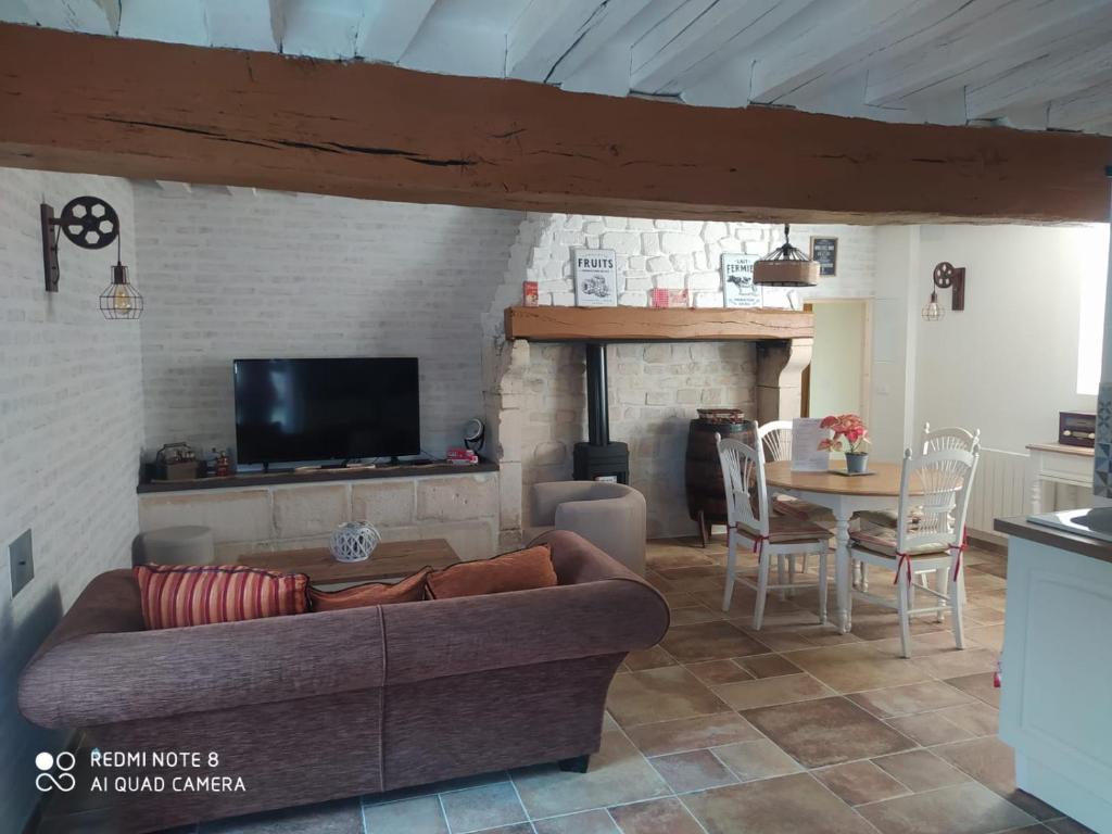 a living room with a couch and a table at O’Pontpoint d’Autrefois in Pontpoint