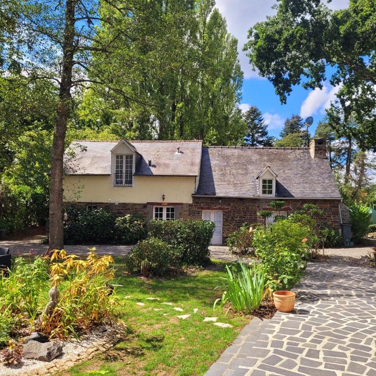 une ancienne maison en briques avec un jardin en face de celle-ci dans l'établissement Les Bruyères Rebecca, à Pleugueneuc