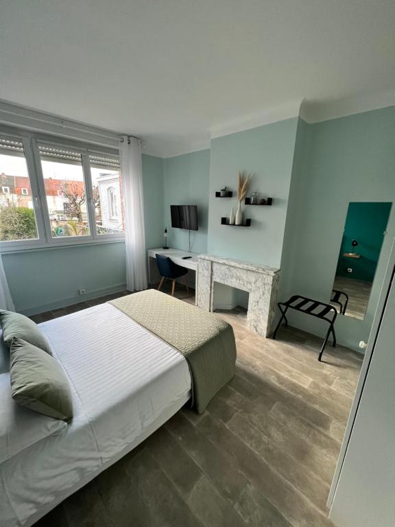 a bedroom with a bed and a desk in it at Hotel Joly in Armentières