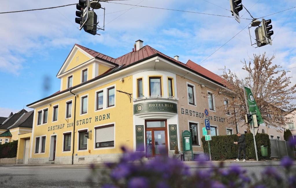 a yellow building on the corner of a street at Hotel Blie, Bed & Breakfast, Self Check-in in Horn