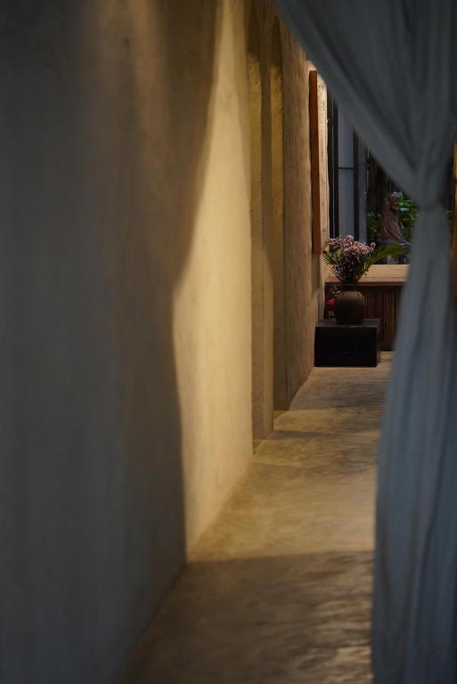 an alley with a blue curtain in a building at Dechiu in Hoi An