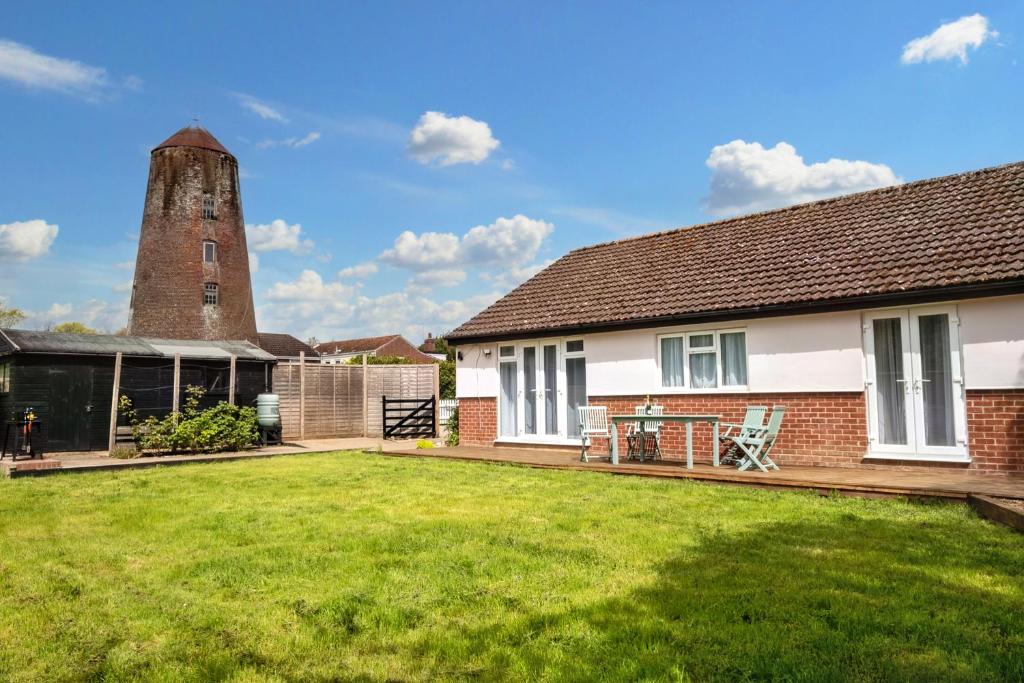 a house with a yard with a tower at Mill House Bungalow in Potter Heigham