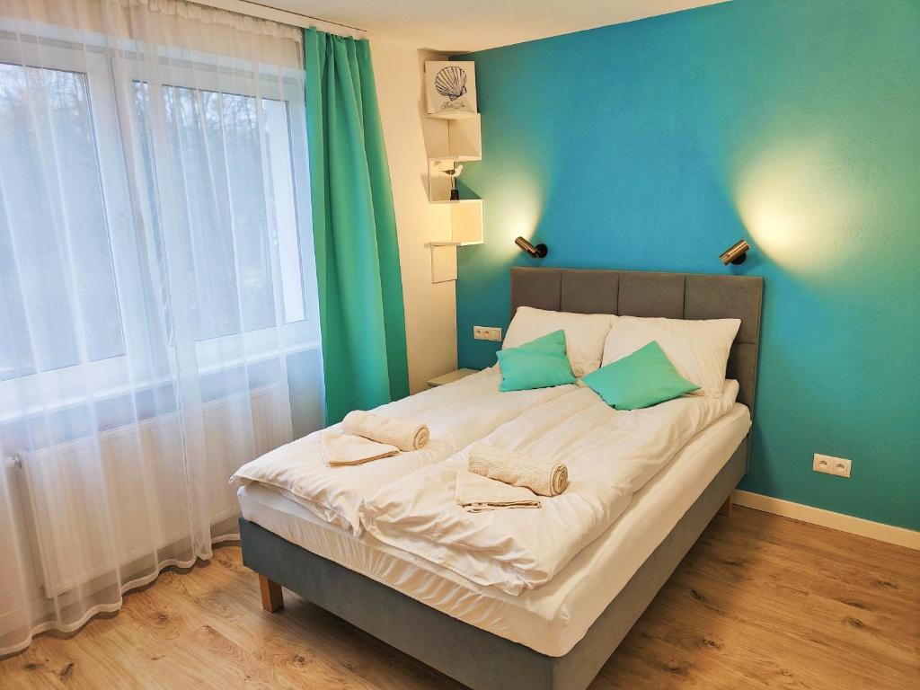 sypialnia z dużym łóżkiem z niebieskimi ścianami w obiekcie Leśny Zakątek w Gdańsku