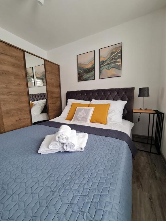 ein Schlafzimmer mit einem Bett mit Handtüchern darauf in der Unterkunft Apartamenty Górski Kryształ in Murzasichle