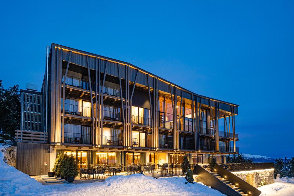 ein großes Gebäude im Schnee in der Nacht in der Unterkunft Olangerhof Hotel & Spa in Olang