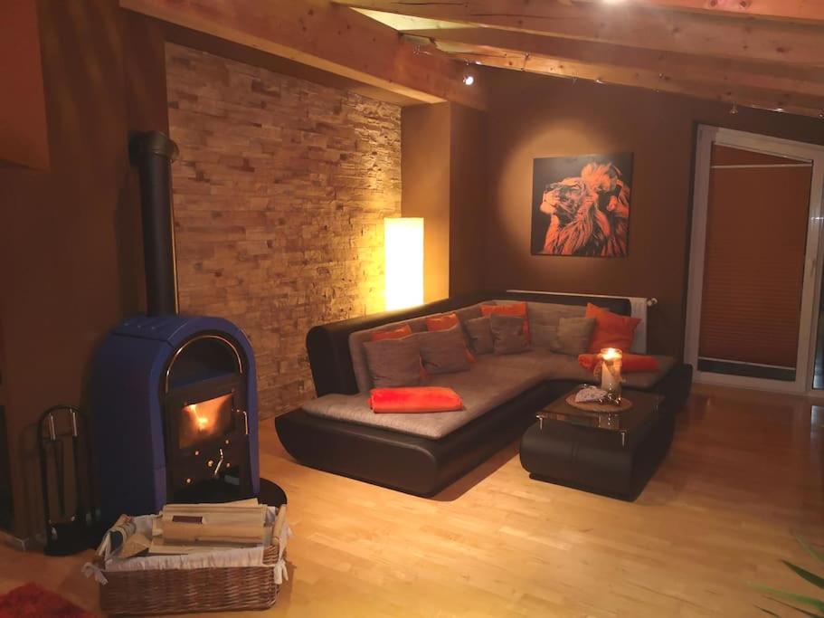 ein Wohnzimmer mit einem Sofa und einem Kamin in der Unterkunft Dachgeschosswohnung am Waldrand in Arzl im Pitztal