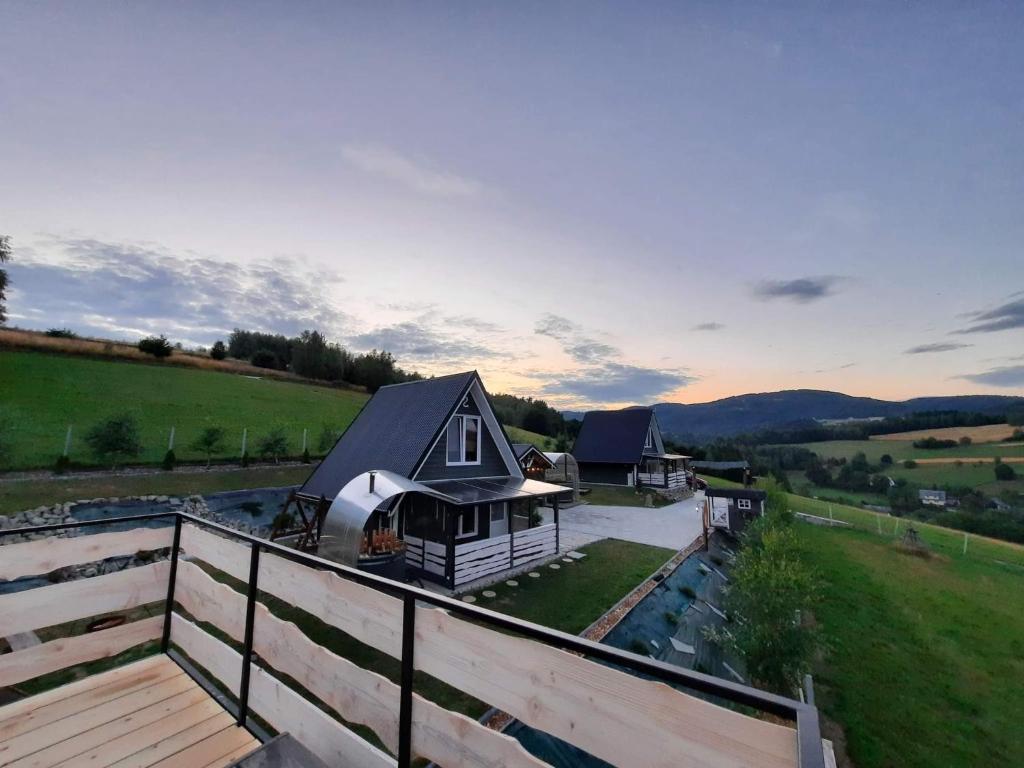 a house with a roof on top of a fence at Domki Dwa in Limanowa