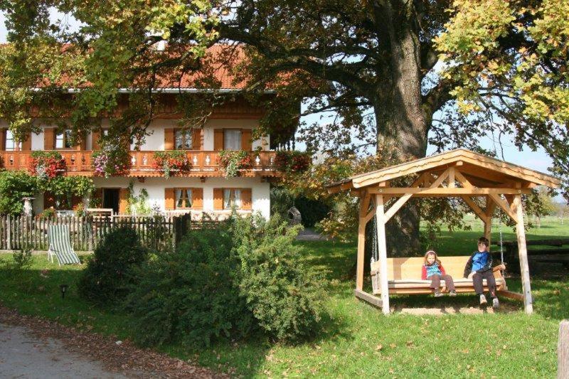 Ein Junge und ein Mädchen sitzen auf einer Bank in einem Pavillon in der Unterkunft Braunhof in Bad Feilnbach
