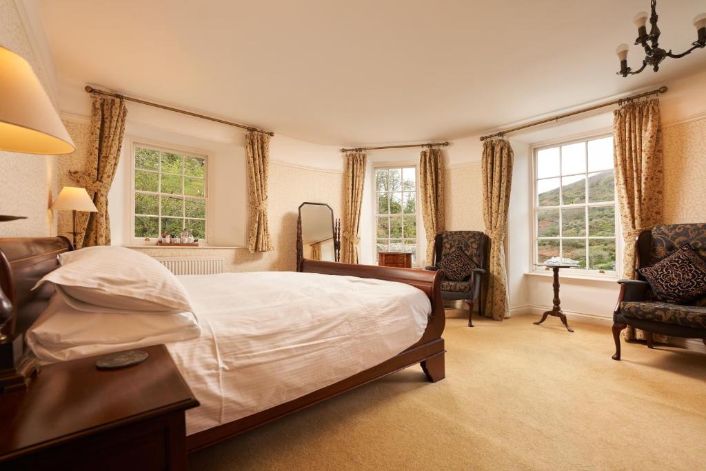 um quarto com uma cama grande e 2 janelas em The Wellington Hotel em Boscastle