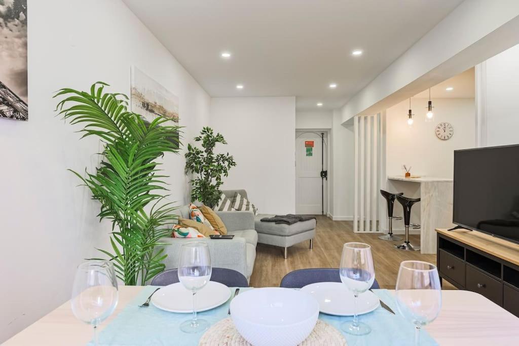 Apartamento Magnifico em Oeiras في باكو دي أركوس: غرفة معيشة مع طاولة وكؤوس للنبيذ